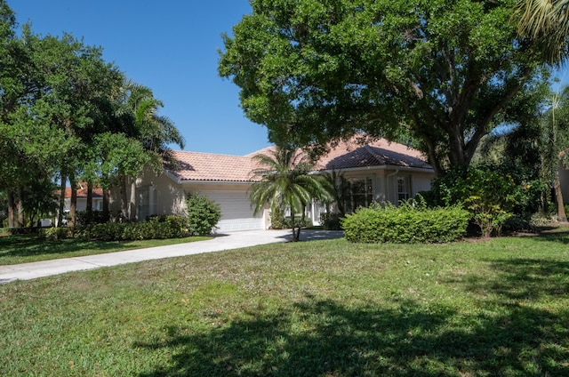 view of front of house featuring a tile roof, a front yard, stucco siding, driveway, and an attached garage