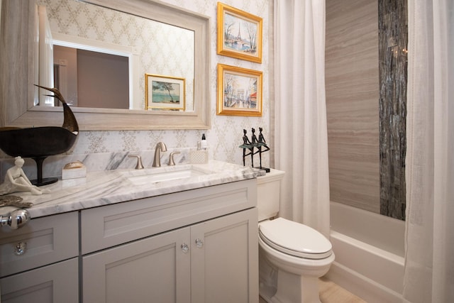 bathroom with toilet, wallpapered walls, vanity, and shower / bath combo