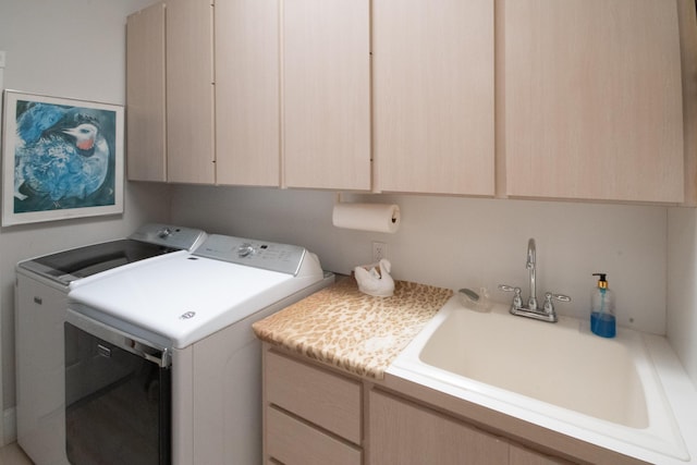 laundry area with separate washer and dryer, cabinet space, and a sink