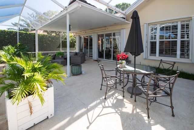 view of patio featuring glass enclosure and outdoor dining space