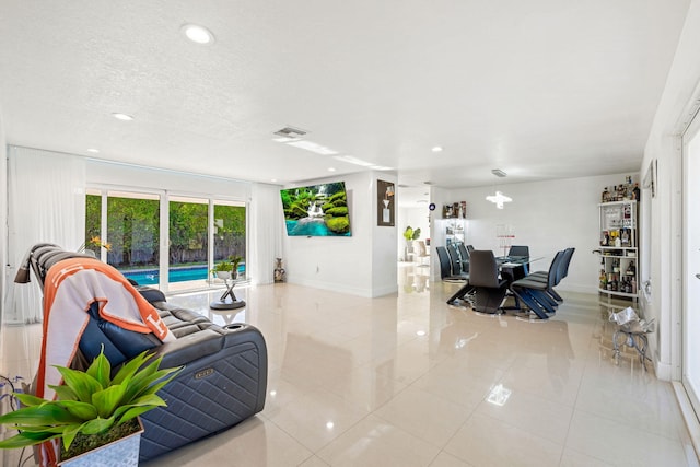 living room featuring light tile patterned floors, visible vents, recessed lighting, and a textured ceiling