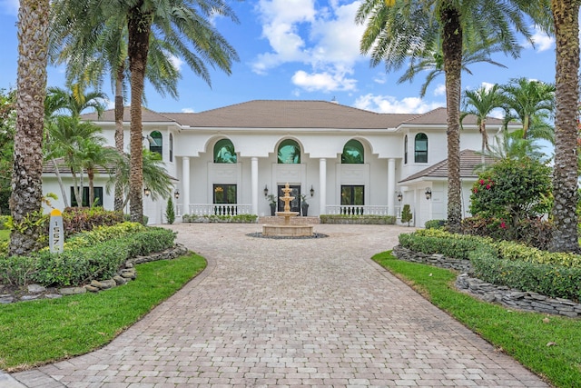 mediterranean / spanish-style house featuring stucco siding, curved driveway, and a garage