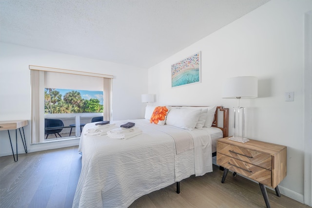 bedroom featuring access to exterior and wood finished floors