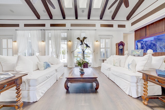 living area with beamed ceiling, wood finished floors, and a ceiling fan
