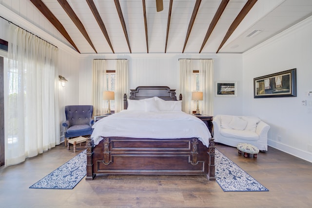 bedroom with wood finished floors, vaulted ceiling with beams, visible vents, and multiple windows