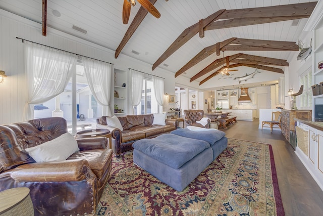 living area featuring a ceiling fan, wood finished floors, vaulted ceiling with beams, a fireplace, and visible vents