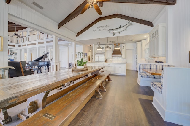 dining area featuring beamed ceiling, ceiling fan, and dark wood finished floors
