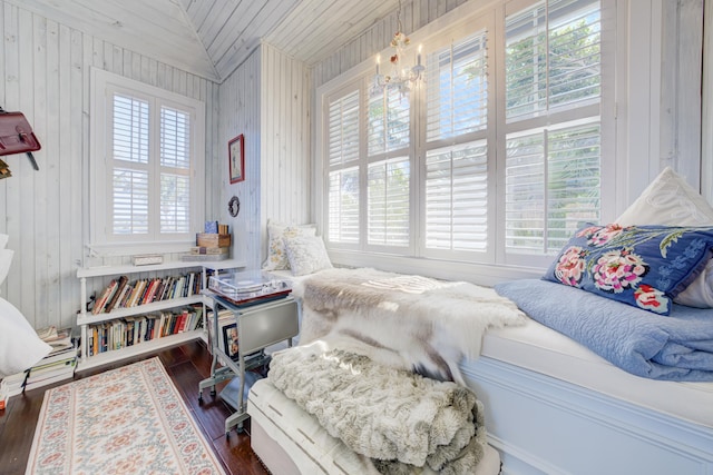 bedroom with lofted ceiling, wooden ceiling, wood walls, and dark wood finished floors
