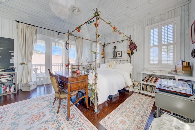 bedroom with hardwood / wood-style floors, wooden walls, wooden ceiling, lofted ceiling, and access to outside