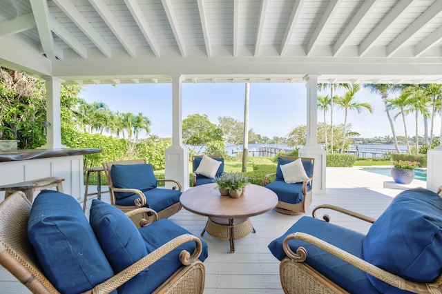exterior space featuring a deck with water view, beam ceiling, and hardwood / wood-style floors