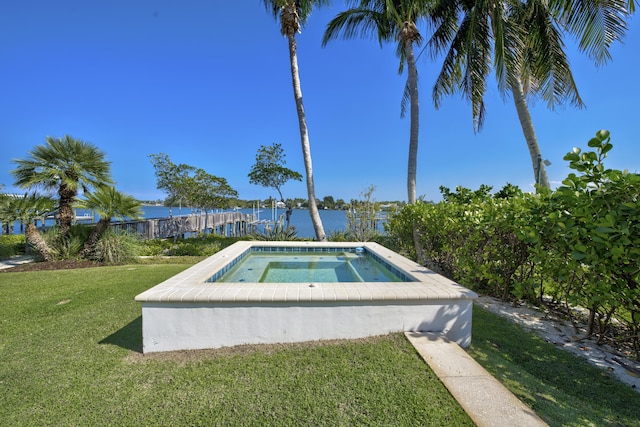 view of swimming pool with a yard and an in ground hot tub