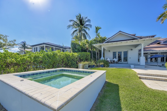 view of swimming pool with french doors, a yard, and an in ground hot tub