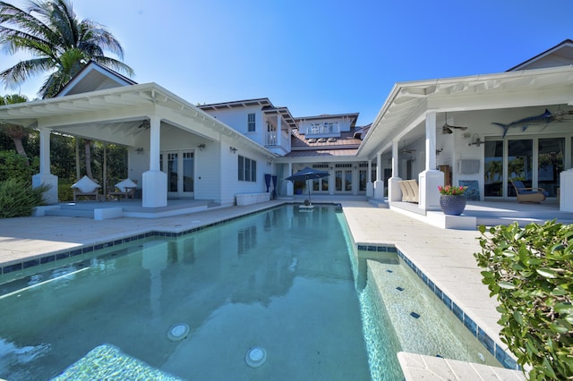 outdoor pool featuring ceiling fan, french doors, and a patio area