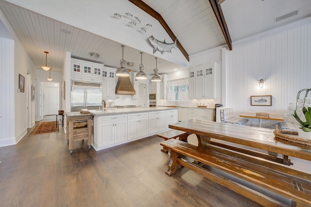kitchen featuring white cabinets, built in appliances, dark wood-style flooring, and a kitchen island with sink