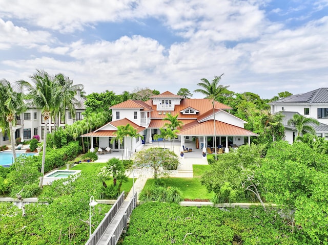 rear view of house with a gazebo, metal roof, a patio, and a standing seam roof