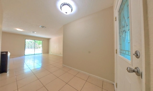 unfurnished room featuring light tile patterned floors, visible vents, and baseboards