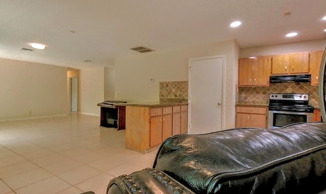 kitchen featuring light tile patterned floors, visible vents, a peninsula, stainless steel range with electric stovetop, and under cabinet range hood