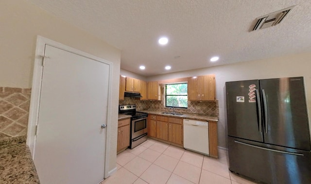 kitchen featuring visible vents, under cabinet range hood, freestanding refrigerator, electric stove, and white dishwasher