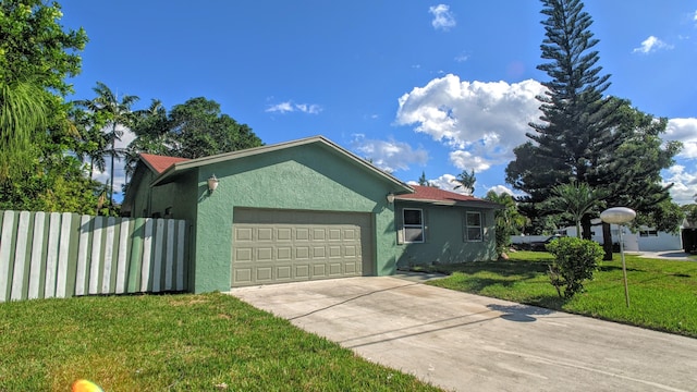 ranch-style home featuring fence, stucco siding, a front lawn, concrete driveway, and a garage