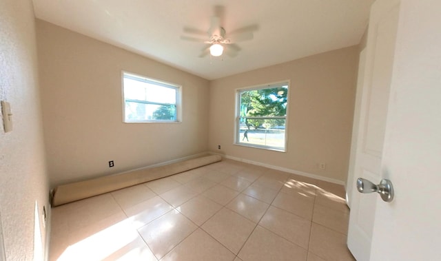 spare room with light tile patterned flooring, ceiling fan, and baseboards