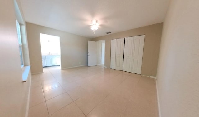 unfurnished bedroom with visible vents, a ceiling fan, a sink, a closet, and baseboards