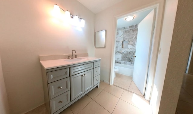 bathroom with toilet, vanity, and tile patterned flooring