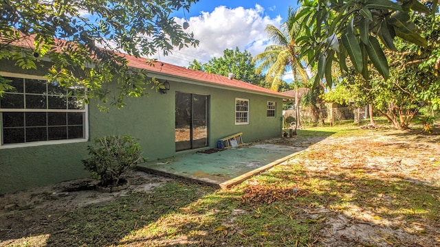 back of property featuring stucco siding, a patio, and fence