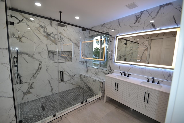 bathroom featuring a marble finish shower, visible vents, double vanity, and a sink