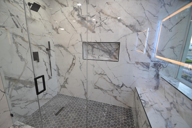 bathroom featuring a marble finish shower