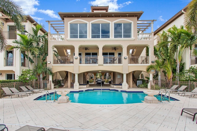 back of property with stucco siding, fence, and ceiling fan