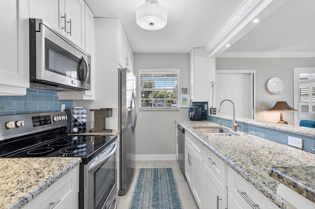 kitchen featuring a sink, stainless steel appliances, white cabinets, crown molding, and decorative backsplash