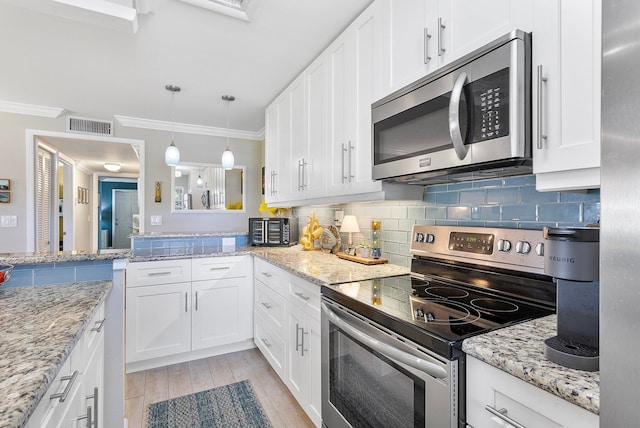 kitchen featuring visible vents, backsplash, appliances with stainless steel finishes, and crown molding