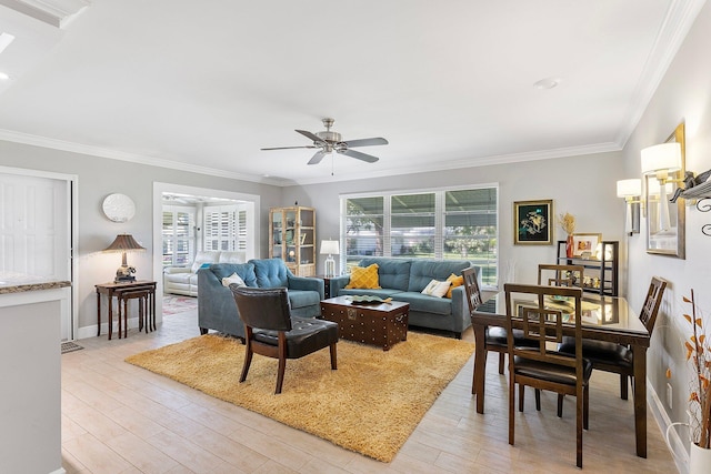 living room featuring baseboards, light wood-type flooring, ceiling fan, and ornamental molding