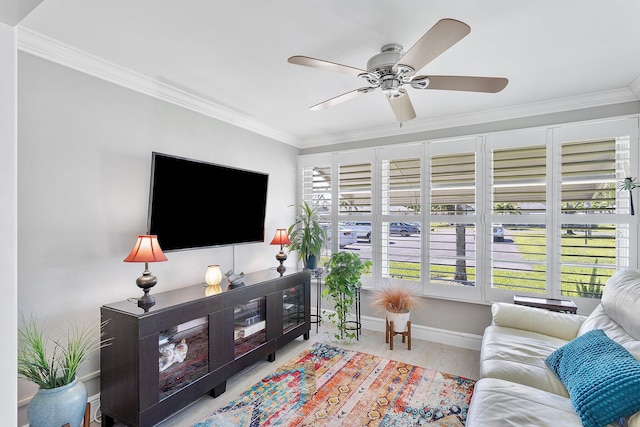 living area featuring crown molding, wood finished floors, baseboards, and ceiling fan