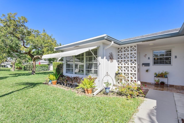 doorway to property featuring a lawn