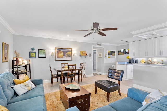 living area featuring visible vents, light wood-type flooring, ceiling fan, and ornamental molding