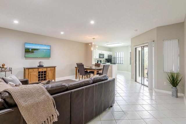 living area featuring light tile patterned floors, recessed lighting, and baseboards