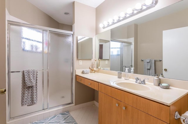 full bath featuring tile patterned floors, vanity, and a shower stall