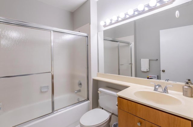 bathroom with vanity, toilet, and shower / bath combination with glass door