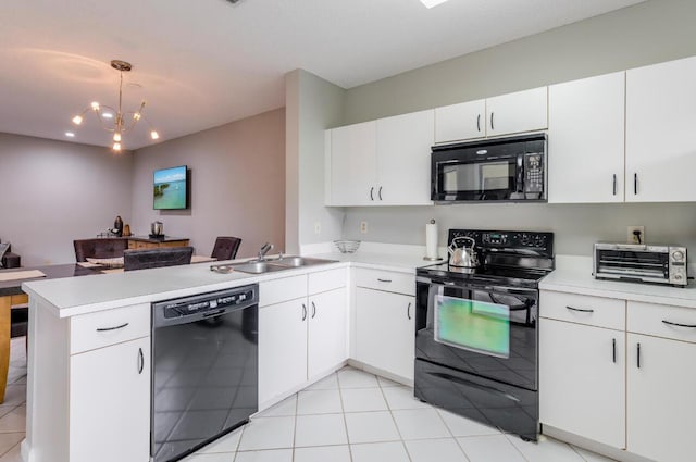 kitchen featuring black appliances, a sink, a toaster, a peninsula, and light countertops