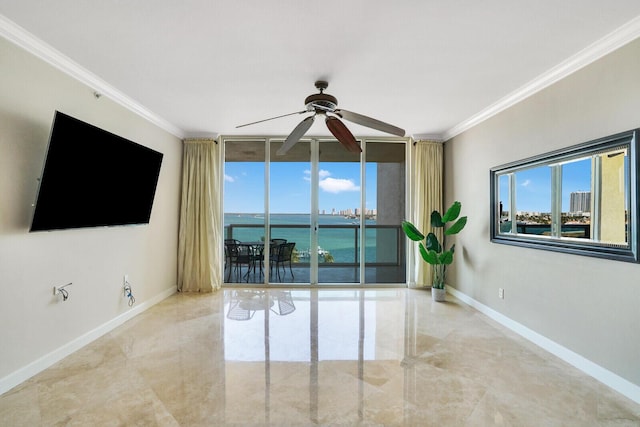 spare room featuring ceiling fan, expansive windows, baseboards, and ornamental molding