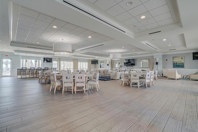2650 Lake Shore Dr Unit 703, Riviera Beach, FL 33404 - dining space with a tray ceiling, light wood-style flooring, and a healthy amount of sunlight