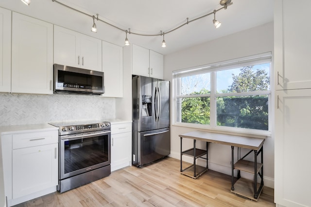 kitchen with white cabinetry, tasteful backsplash, appliances with stainless steel finishes, and light wood finished floors