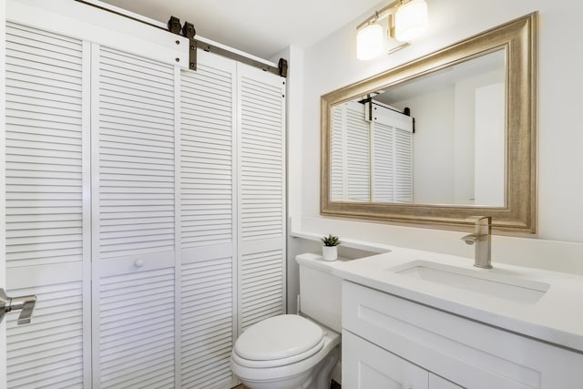 bathroom featuring a closet, toilet, and vanity