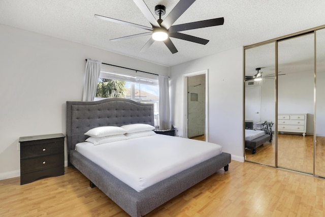 bedroom featuring a closet, ceiling fan, a textured ceiling, and light wood-style floors