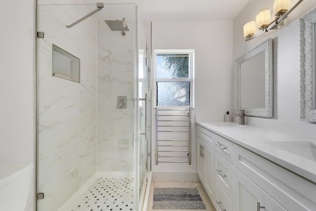 bathroom featuring a shower stall, double vanity, and a sink