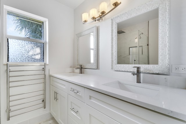 full bath with a sink, a marble finish shower, and a healthy amount of sunlight