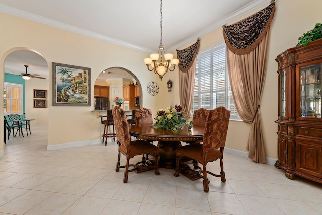 dining space featuring baseboards, arched walkways, ornamental molding, and light tile patterned flooring