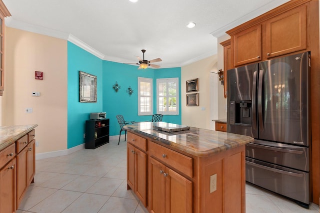 kitchen with crown molding, brown cabinetry, stainless steel refrigerator with ice dispenser, and a kitchen island