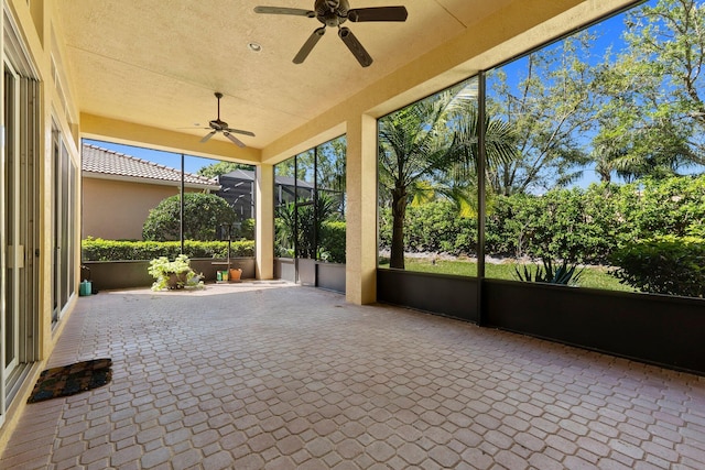 unfurnished sunroom featuring a ceiling fan